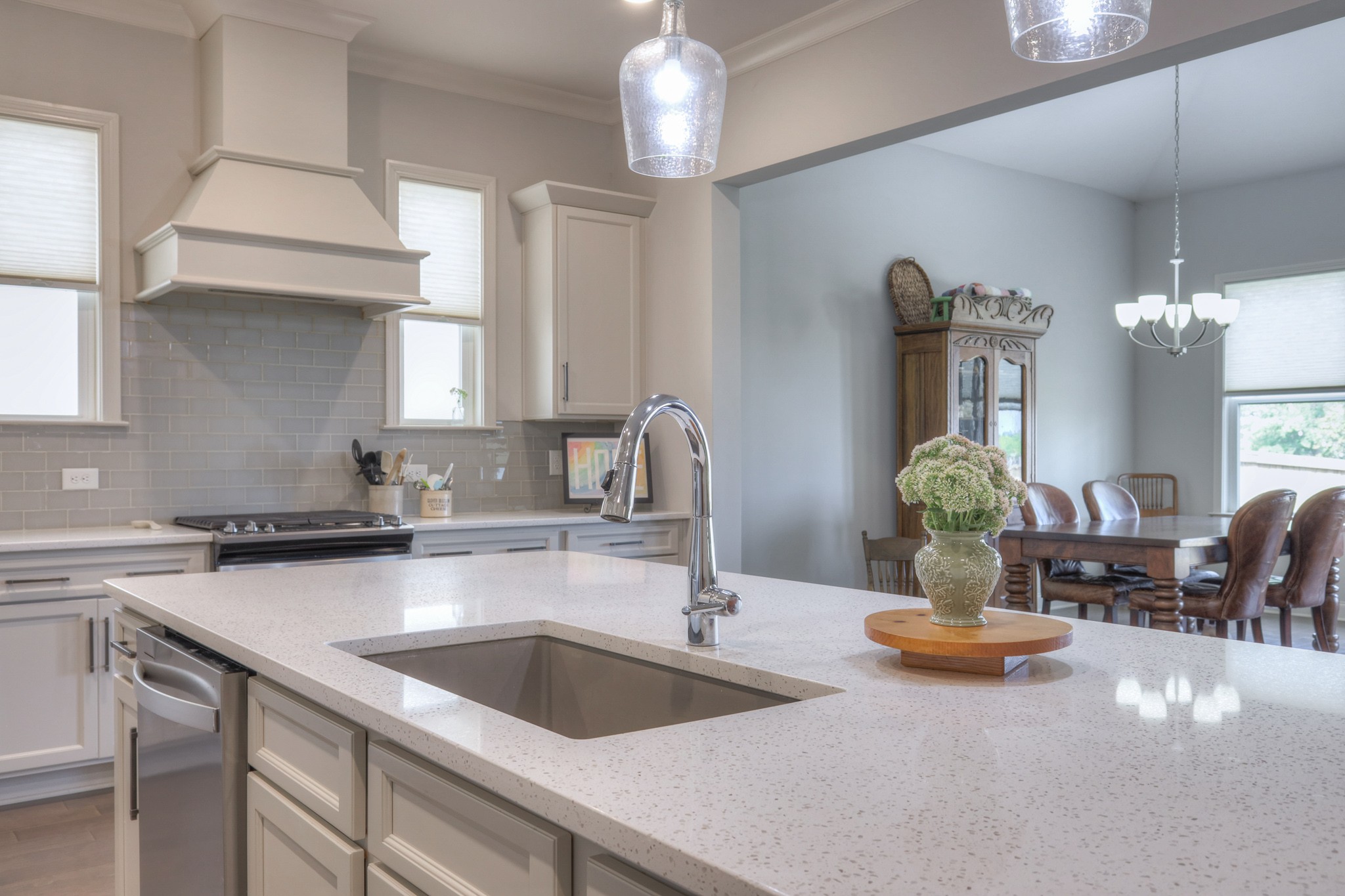 Bright white kitchen with a large quartz island and adjoining dining area.