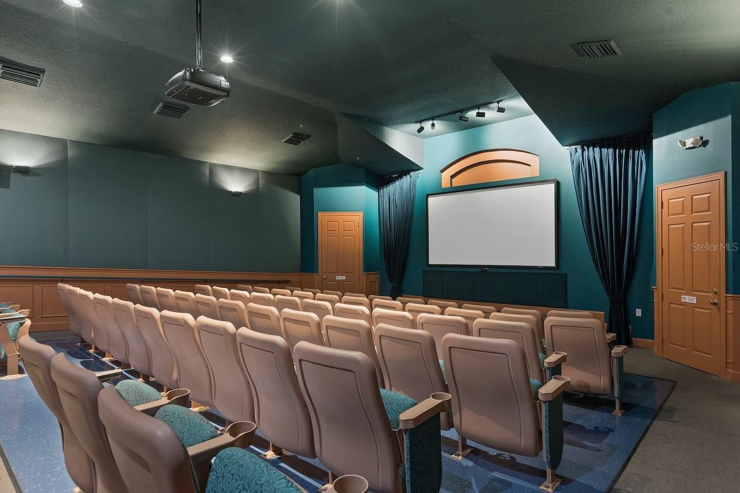 Private theater room with rows of reclining seats facing a large projection screen.