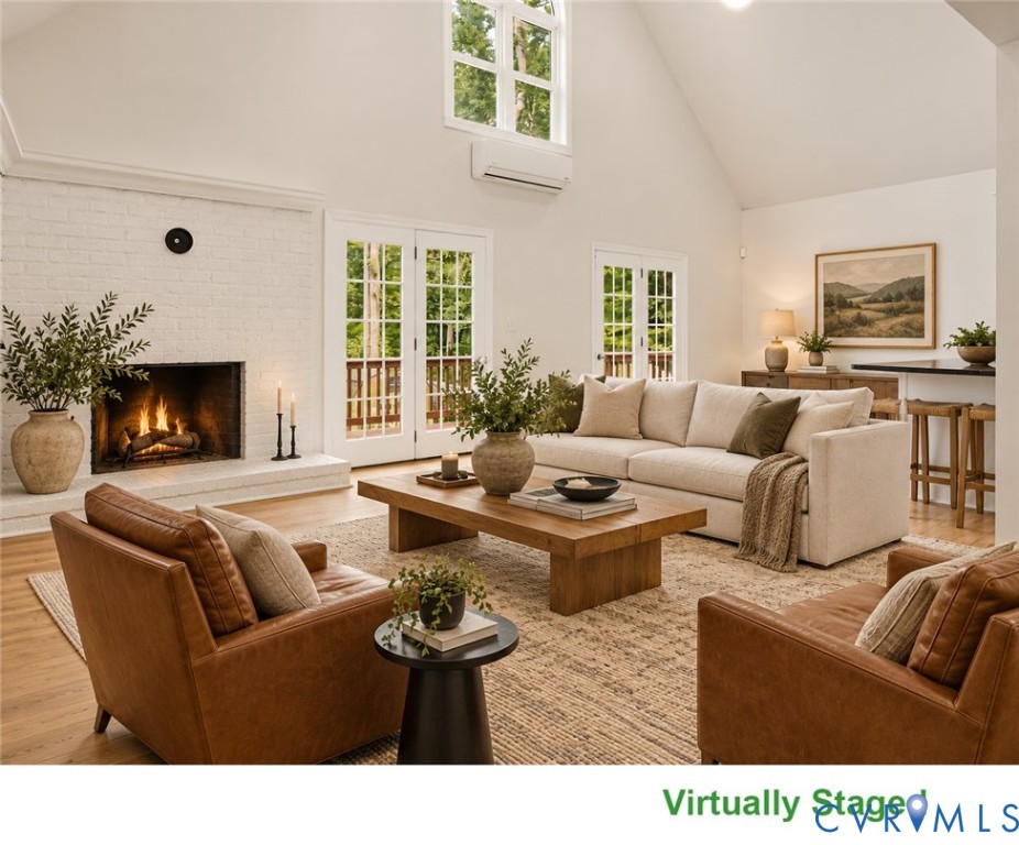 Staged living room with a white brick fireplace, vaulted ceiling, and French doors.