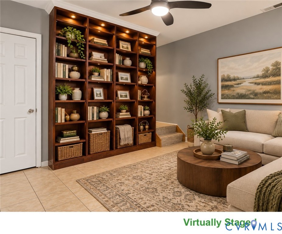 Living room with a floor-to-ceiling bookcase, beige sofa, round coffee table, and ceiling fan.