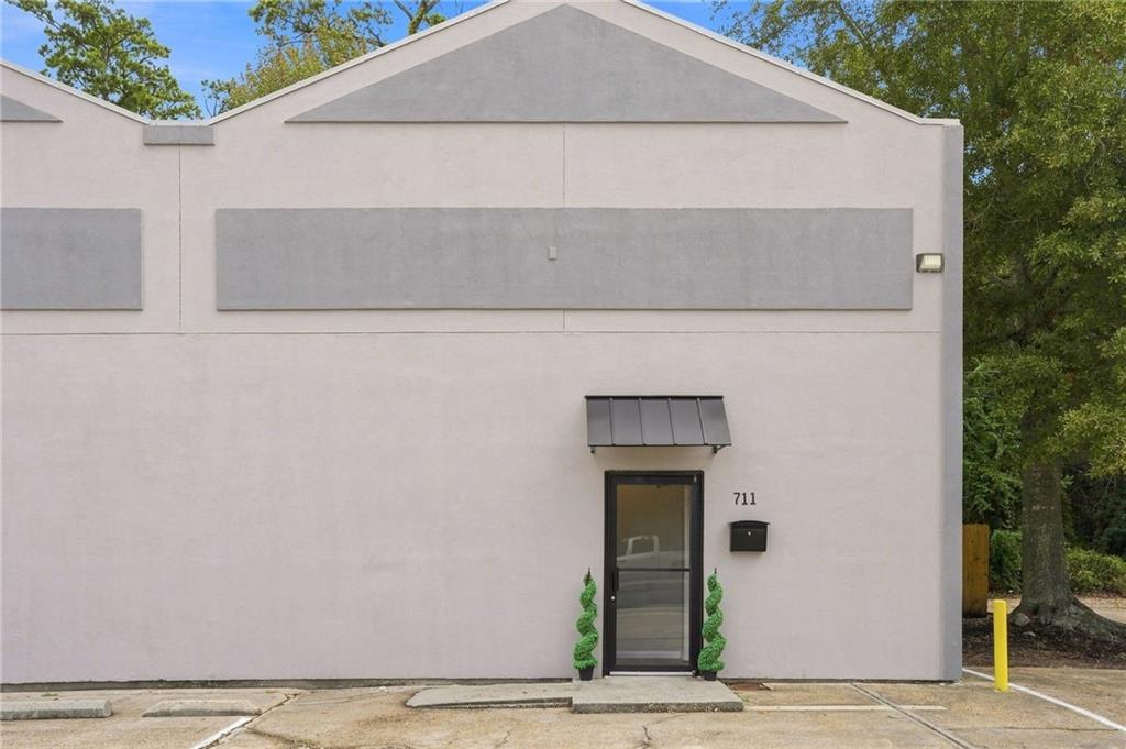 Commercial building entrance with a metal awning and the number 711 above the door.