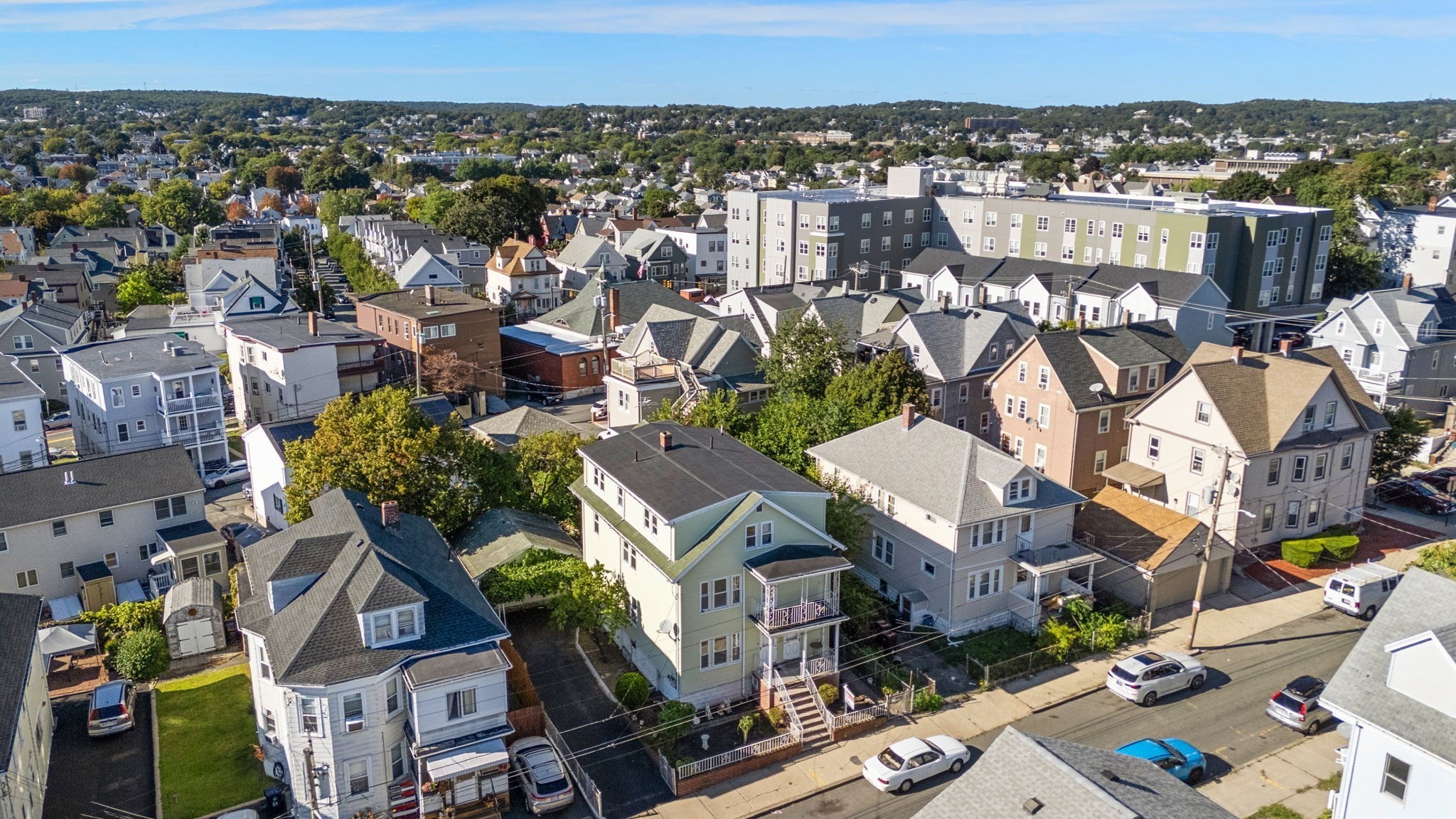 Aerial view of a residential neighborhood with closely spaced homes and a large apartment building.