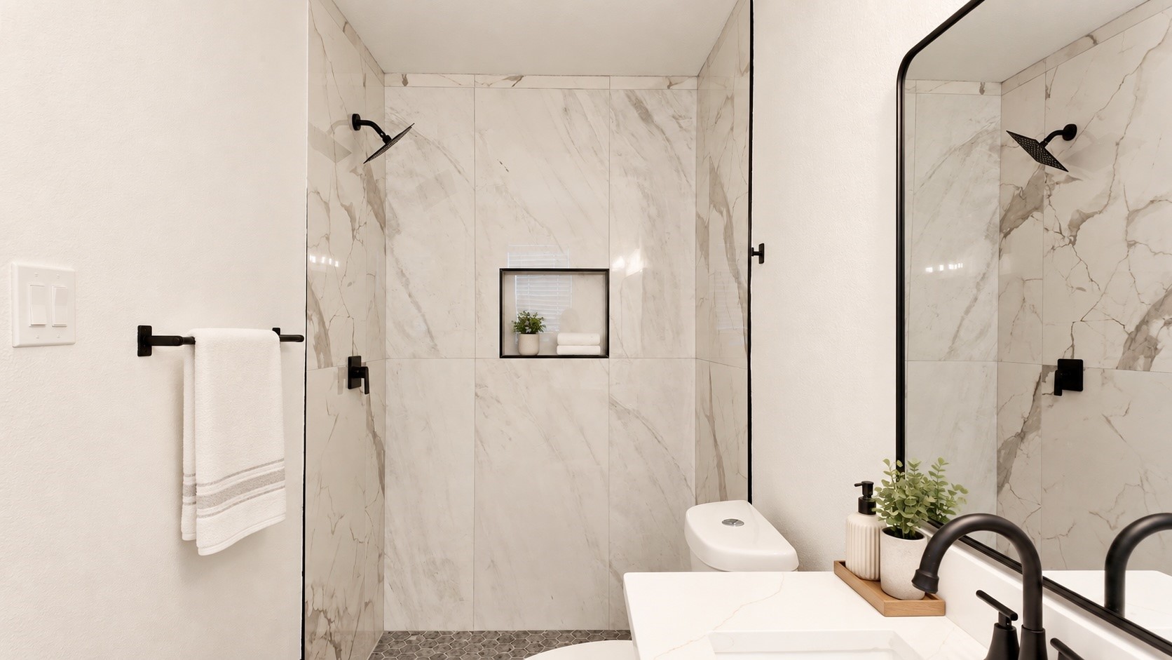 Bathroom with a marble-look walk-in shower, recessed niche, black fixtures, and white vanity.