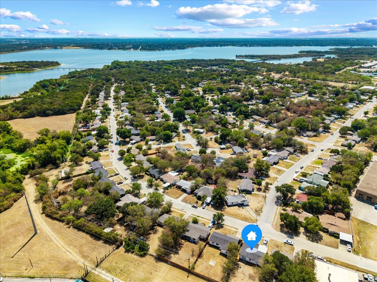 Aerial view of a residential neighborhood beside a broad lake, with a home marked in blue.