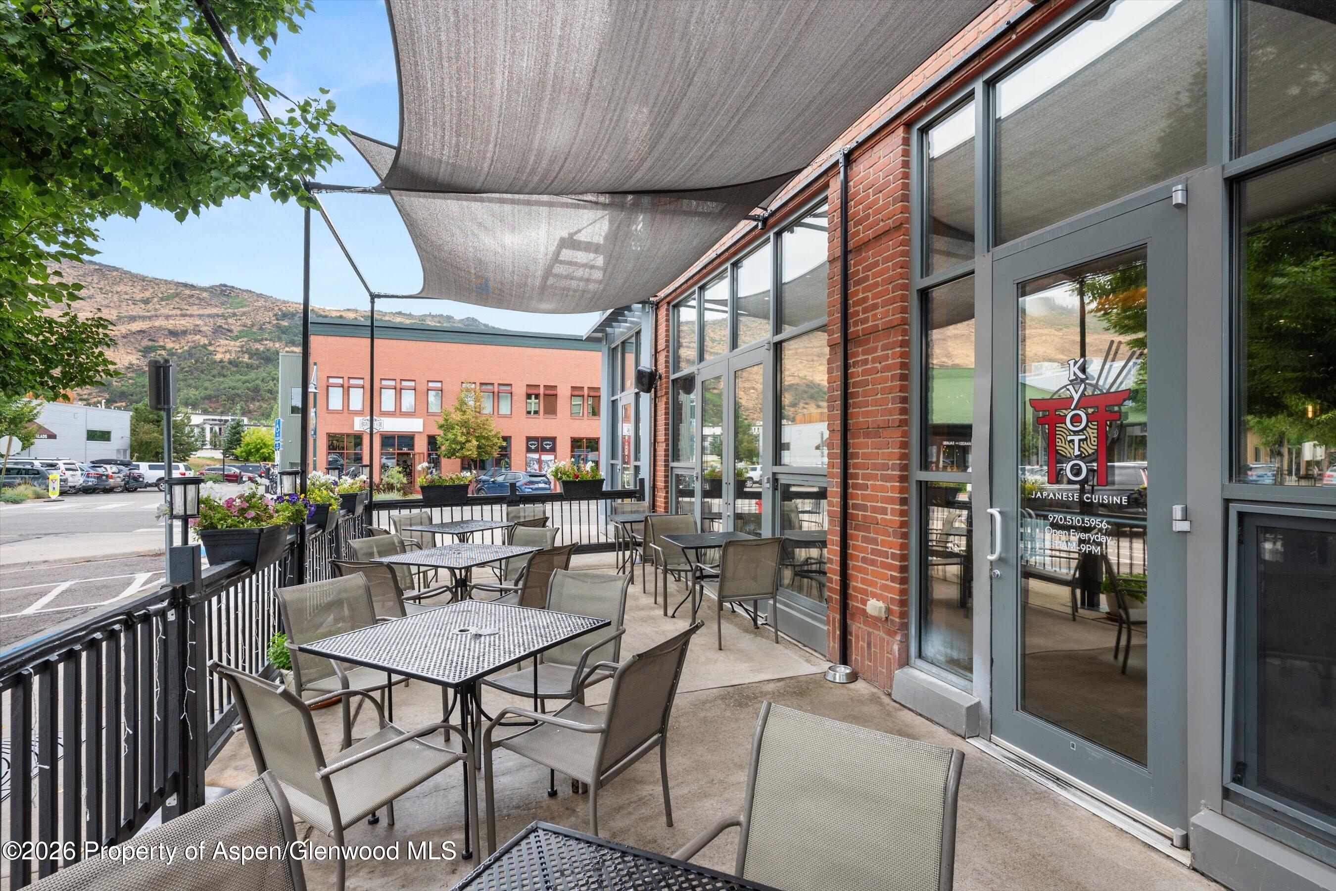 Restaurant patio with shaded seating, flower planters, and the Kyoto Japanese Cuisine entrance.