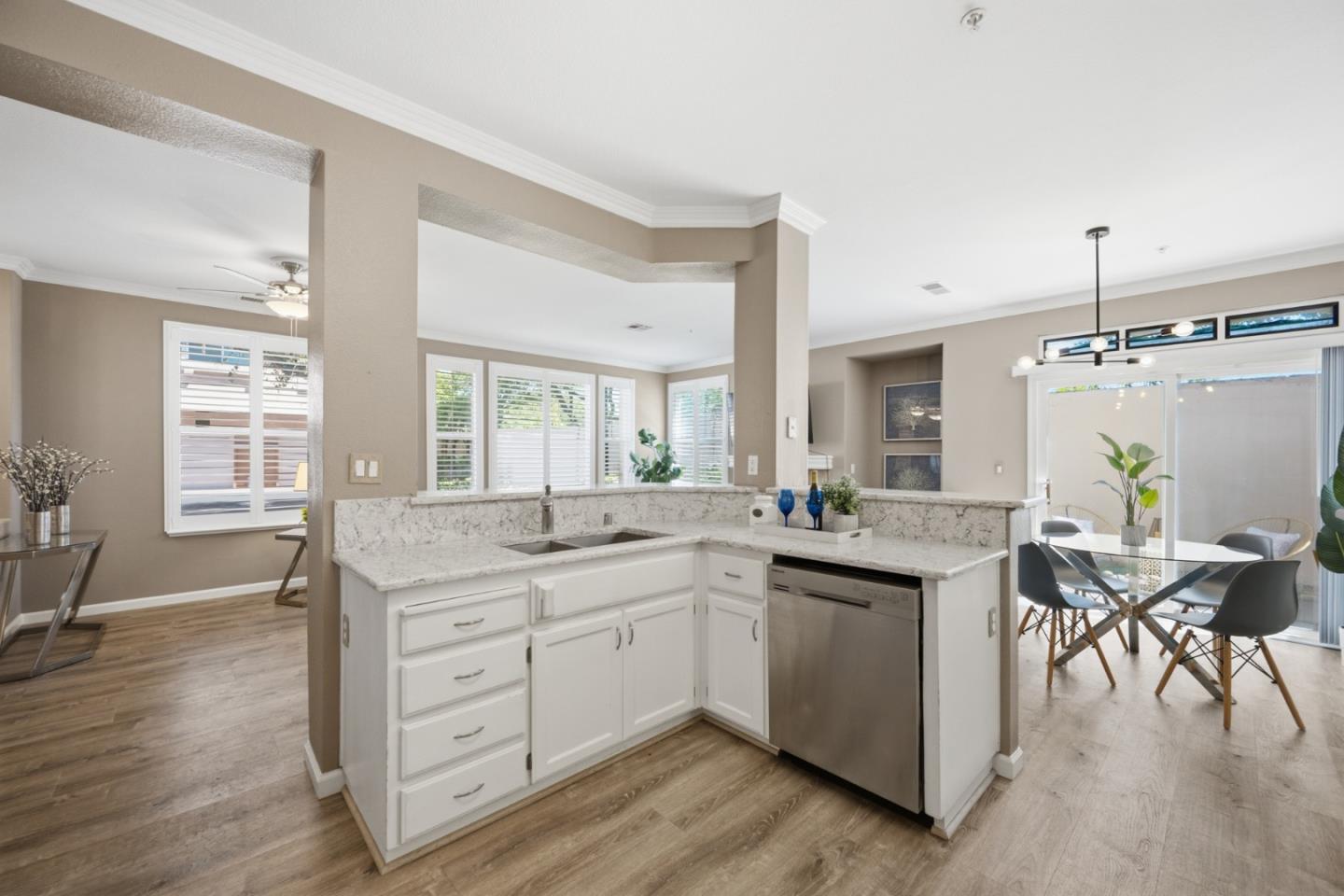 Open kitchen with a marble-patterned island, white cabinetry, and an adjoining dining area.