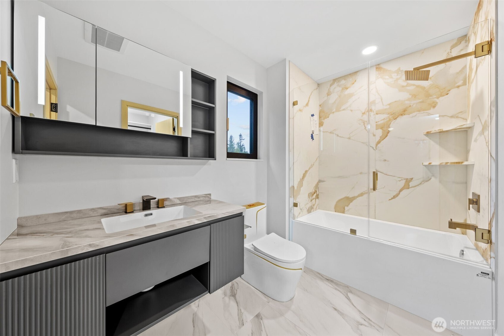 Modern bathroom with a gray vanity, freestanding-style toilet, and gold-veined marble shower surround.