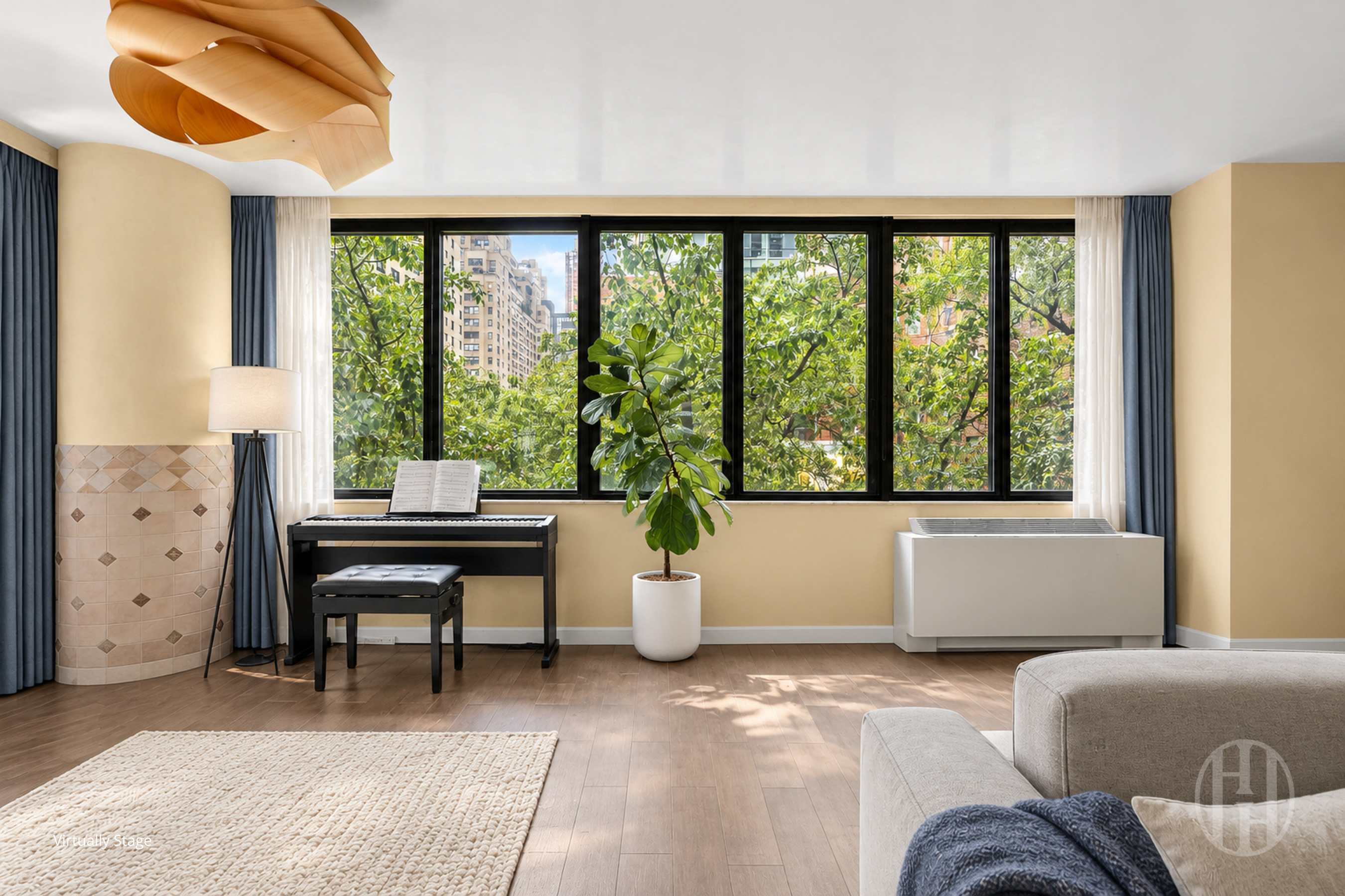 Living room with a piano beside a wide window overlooking leafy trees and apartment buildings.
