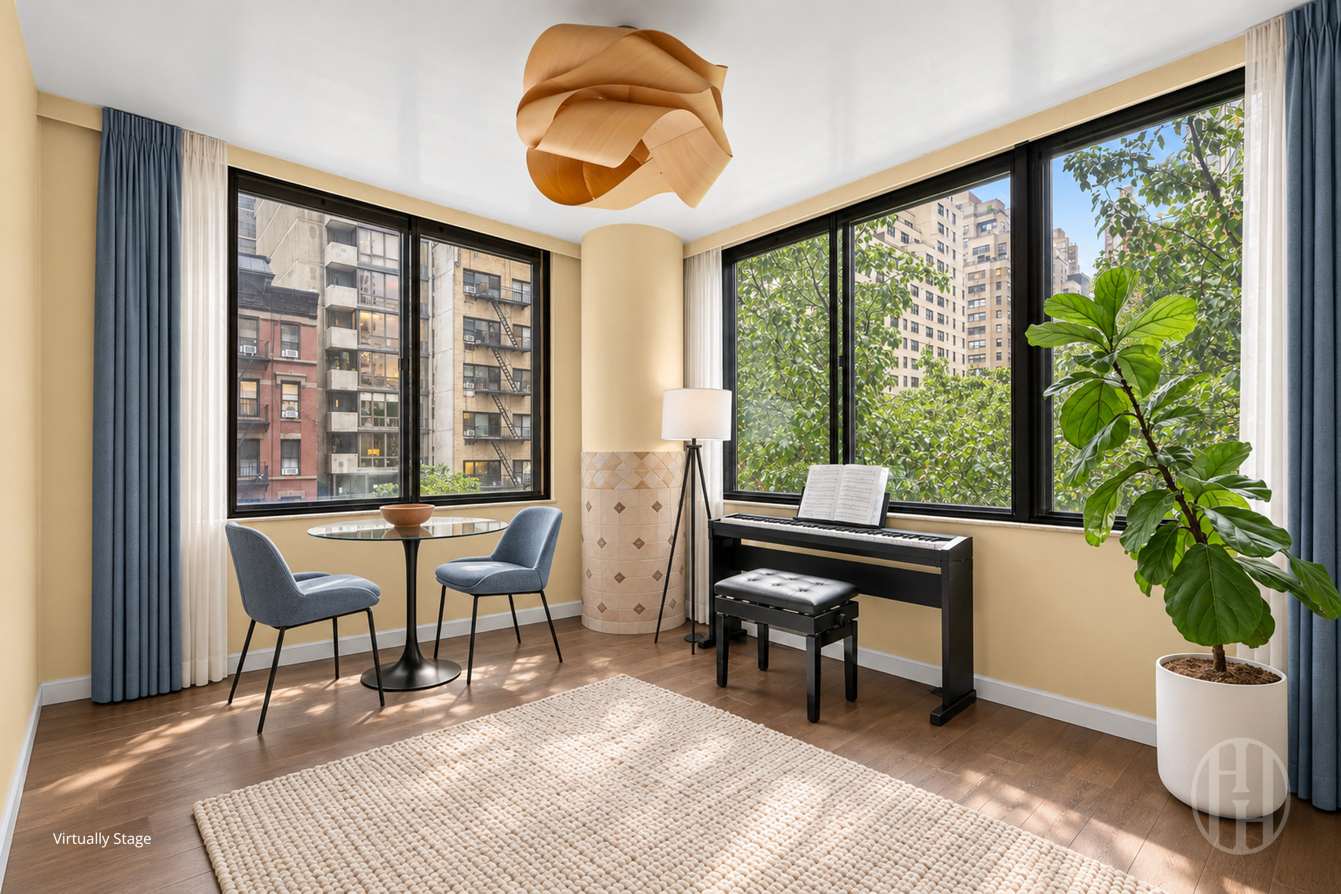 Corner sitting room with a digital piano, large windows, leafy views, and a glass table with blue chairs.