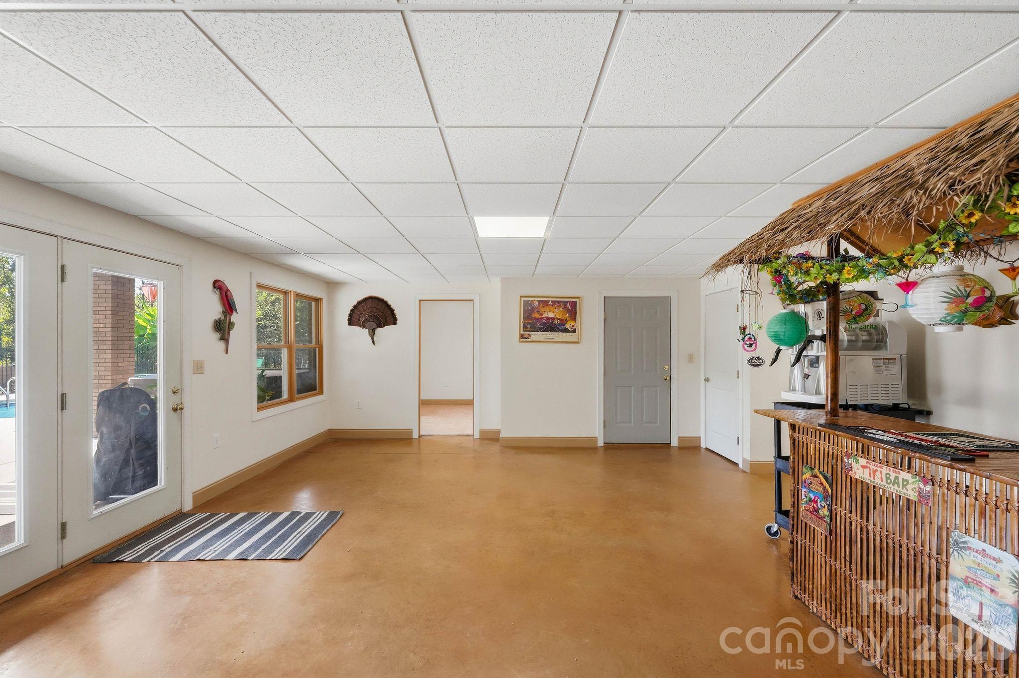Recreation room with a tropical tiki bar and thatched roof.