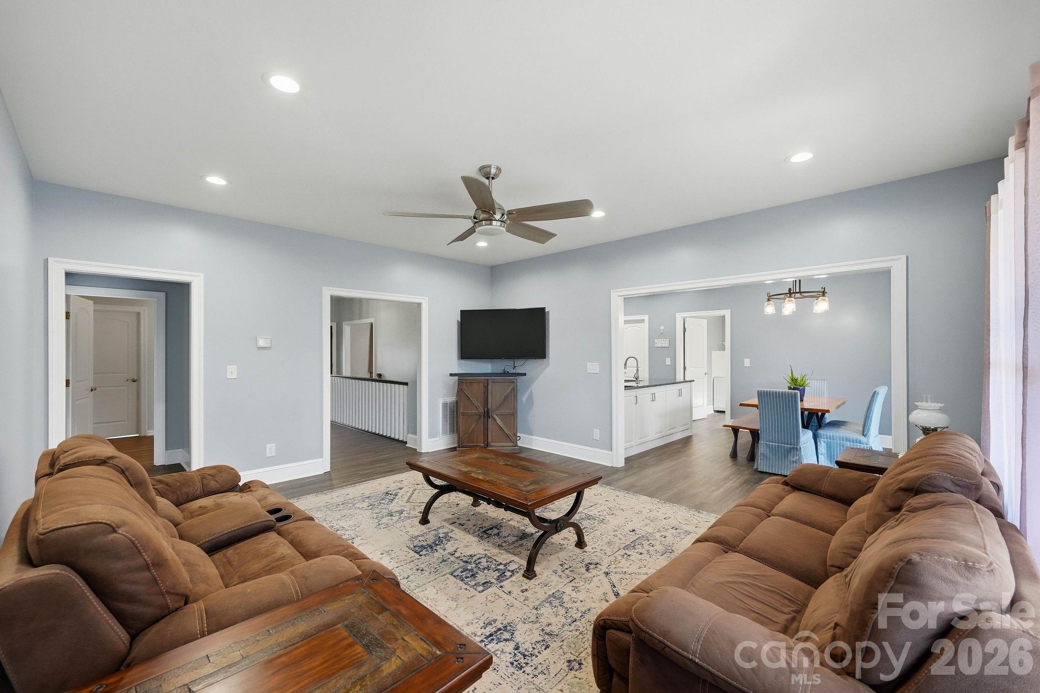 Furnished living room with brown sofas, a wood coffee table, and an adjoining dining area.