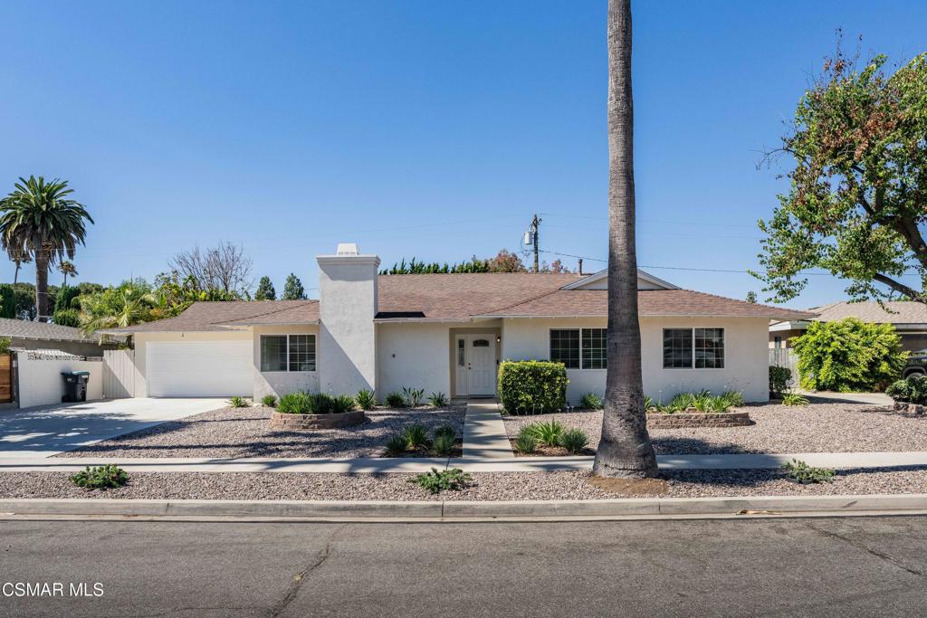 Recently sold single-story home in Texas with a white exterior, attached garage, desert landscaping, and a tall palm tree in front.