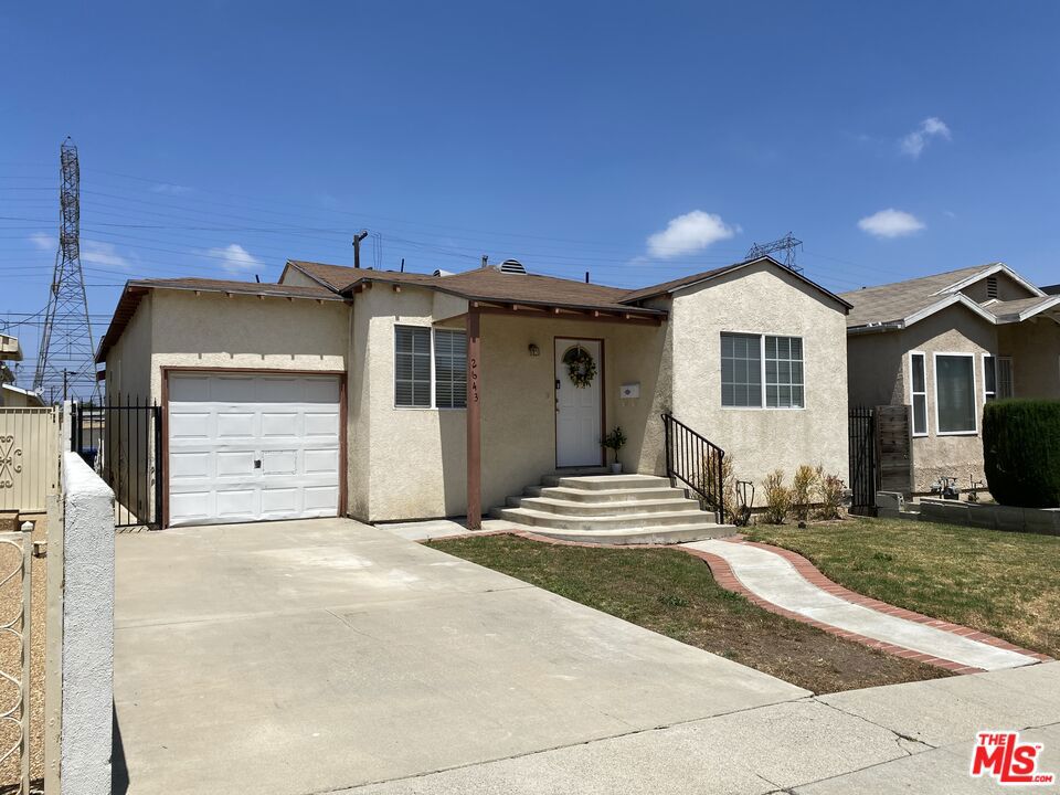 Street view of the single-story home at 2643 S Spaulding Avenue, with an attached garage, front steps, and a curved walkway across the lawn.