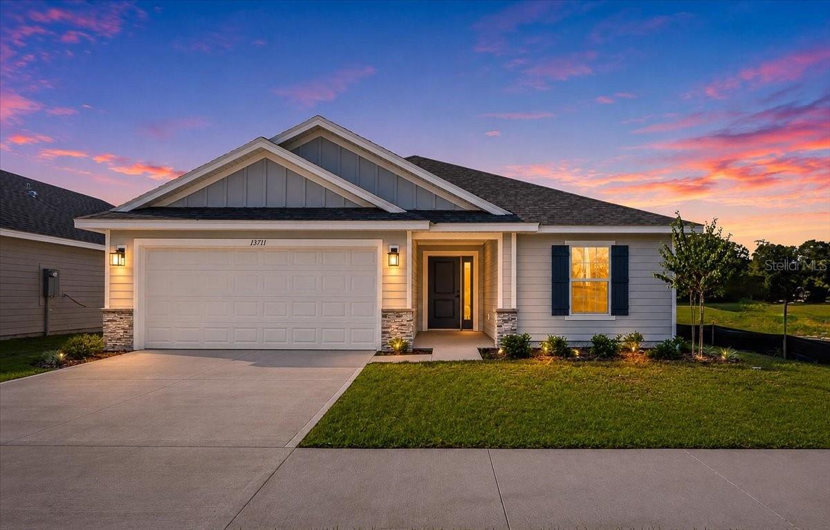 Front exterior of a single-story house with a two-car garage at sunset