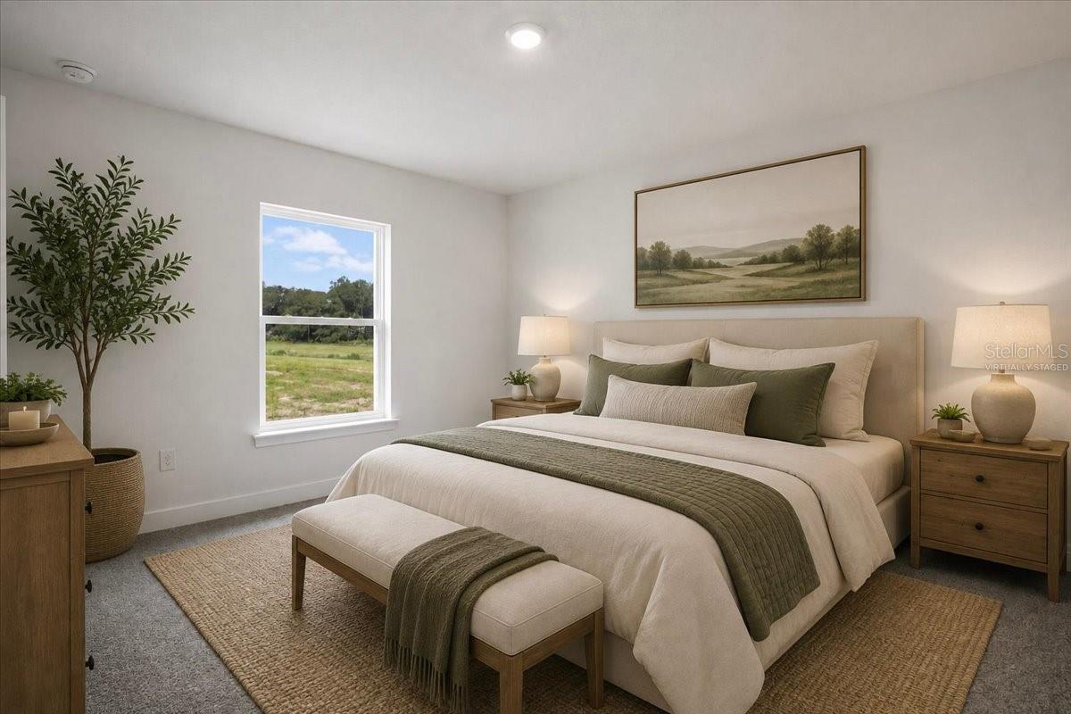 A virtually staged bedroom with a queen-sized bed featuring olive green and beige bedding, a bench at the foot of the bed, nightstands with lamps, a potted plant, and a large framed landscape print hanging on the wall.