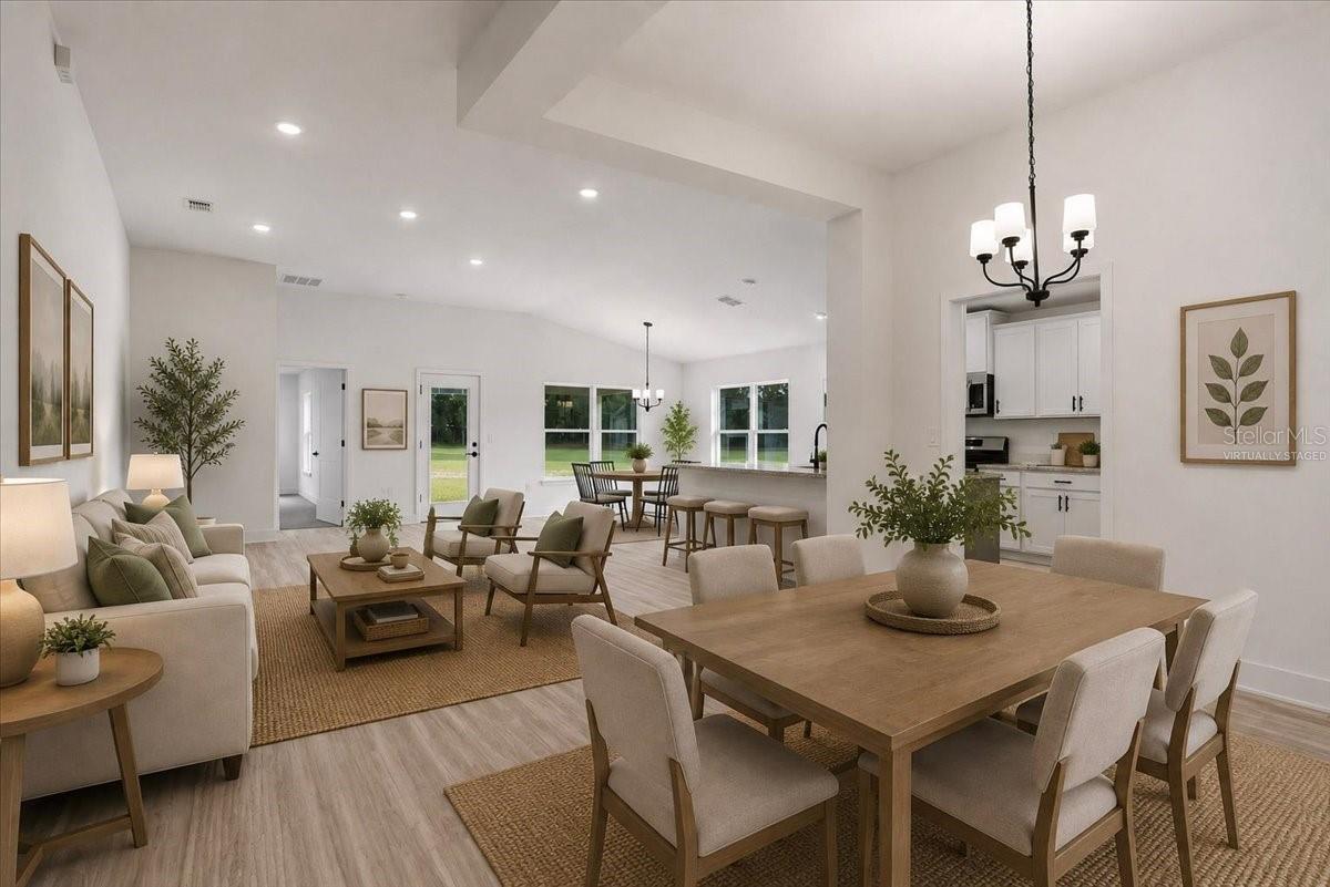 A bright open-concept living and dining area with modern neutral furnishings and vaulted ceilings.