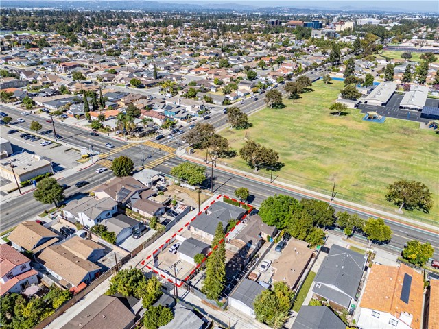 Aerial view showing property boundaries in red overlooking a suburban neighborhood and street intersection