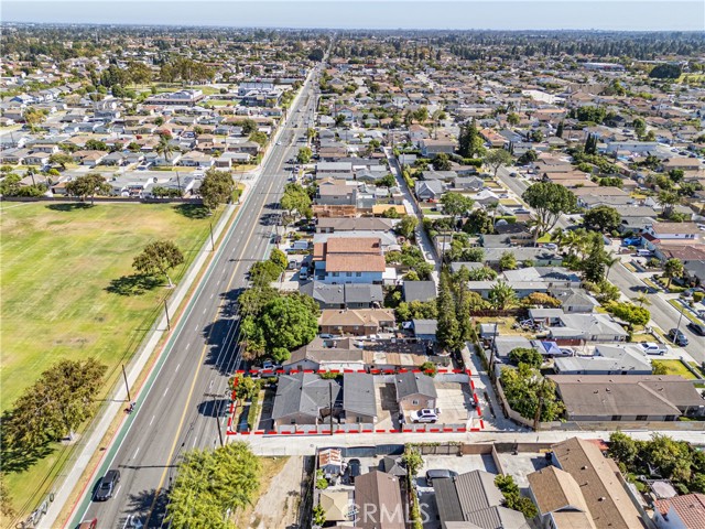 Aerial view showing the property boundaries marked in red, situated along a suburban street with a large field nearby.