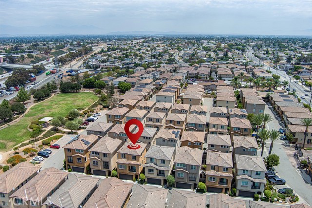 Aerial view of a residential neighborhood with a red location pin pointing at a specific townhouse