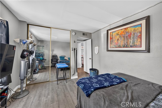 Bedroom featuring gray flooring, mirrored closet doors, and a bed with a space-themed blanket.