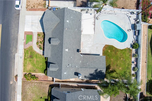 Aerial top-down view of a residential home with a pool and backyard