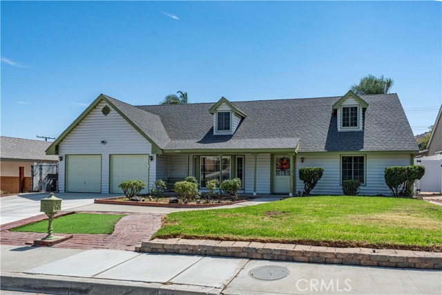 Single-story suburban house with a two-car garage, white siding, and a small front lawn