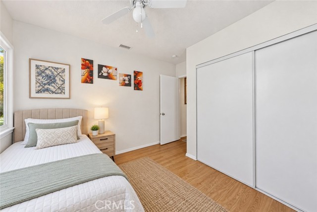 A furnished bedroom with a twin bed, a nightstand, and sliding closet doors.