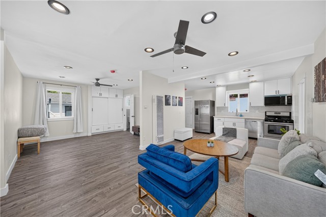 Open concept living room with blue accent chair and view of the kitchen