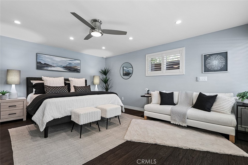 Spacious bedroom at 910 Firmona Avenue with a king bed, two upholstered benches, a sitting area, and a ceiling fan.