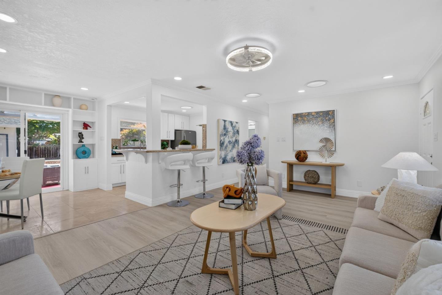 Open-plan living room and kitchen with a breakfast bar and sliding doors to the backyard.