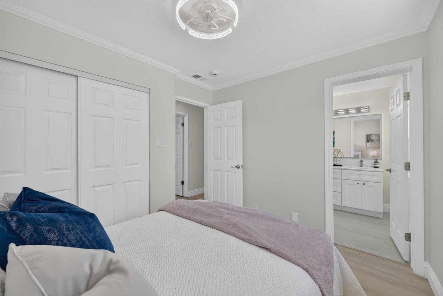 Bedroom with sliding closet doors and an open doorway to an en-suite bathroom.