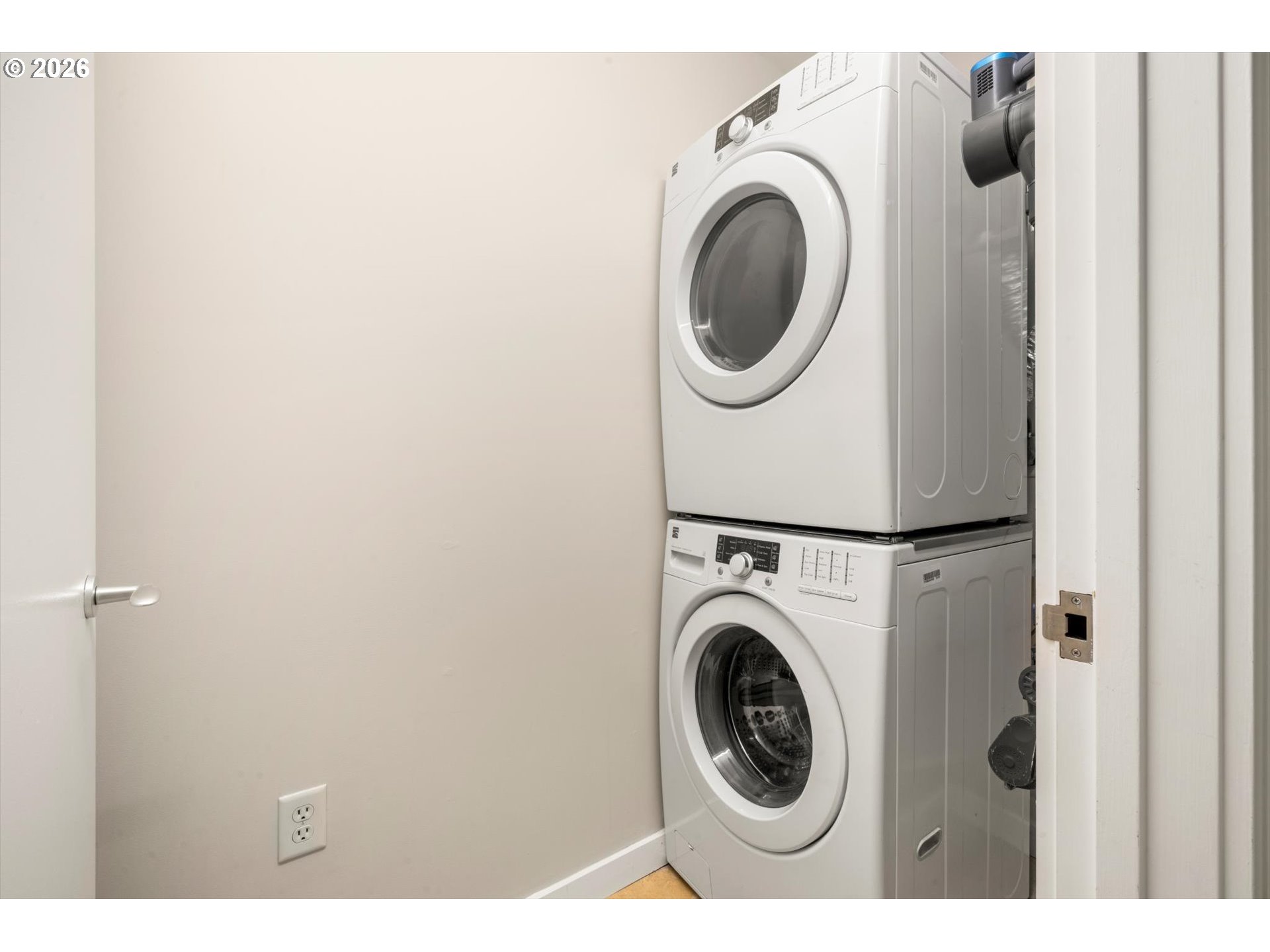 Stacked front-loading washer and dryer in a compact laundry closet.
