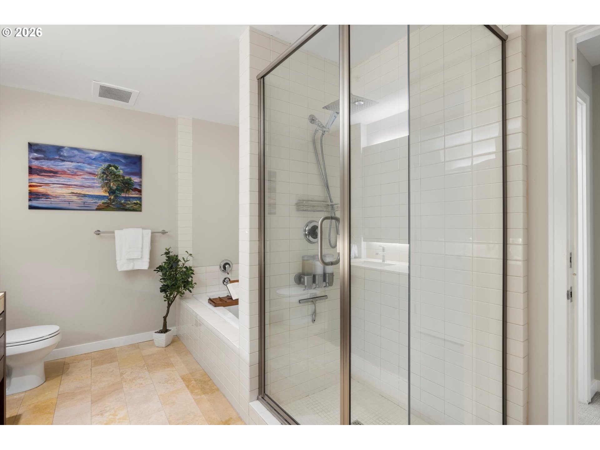 Bathroom with a glass-enclosed tiled shower beside a built-in tub.