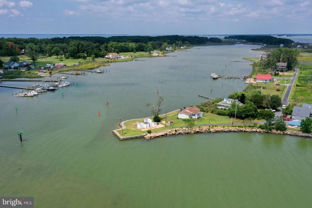 Waterfront home on a rocky point, with a marina and broad inlet.