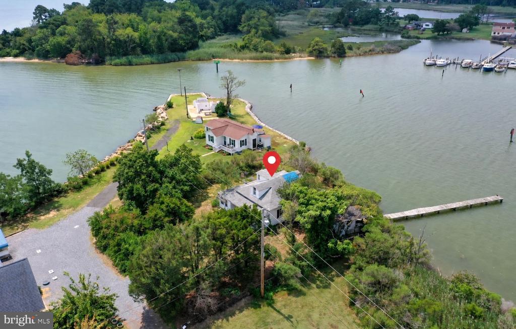 Aerial view of waterfront homes, shoreline, docks, and a red location pin.