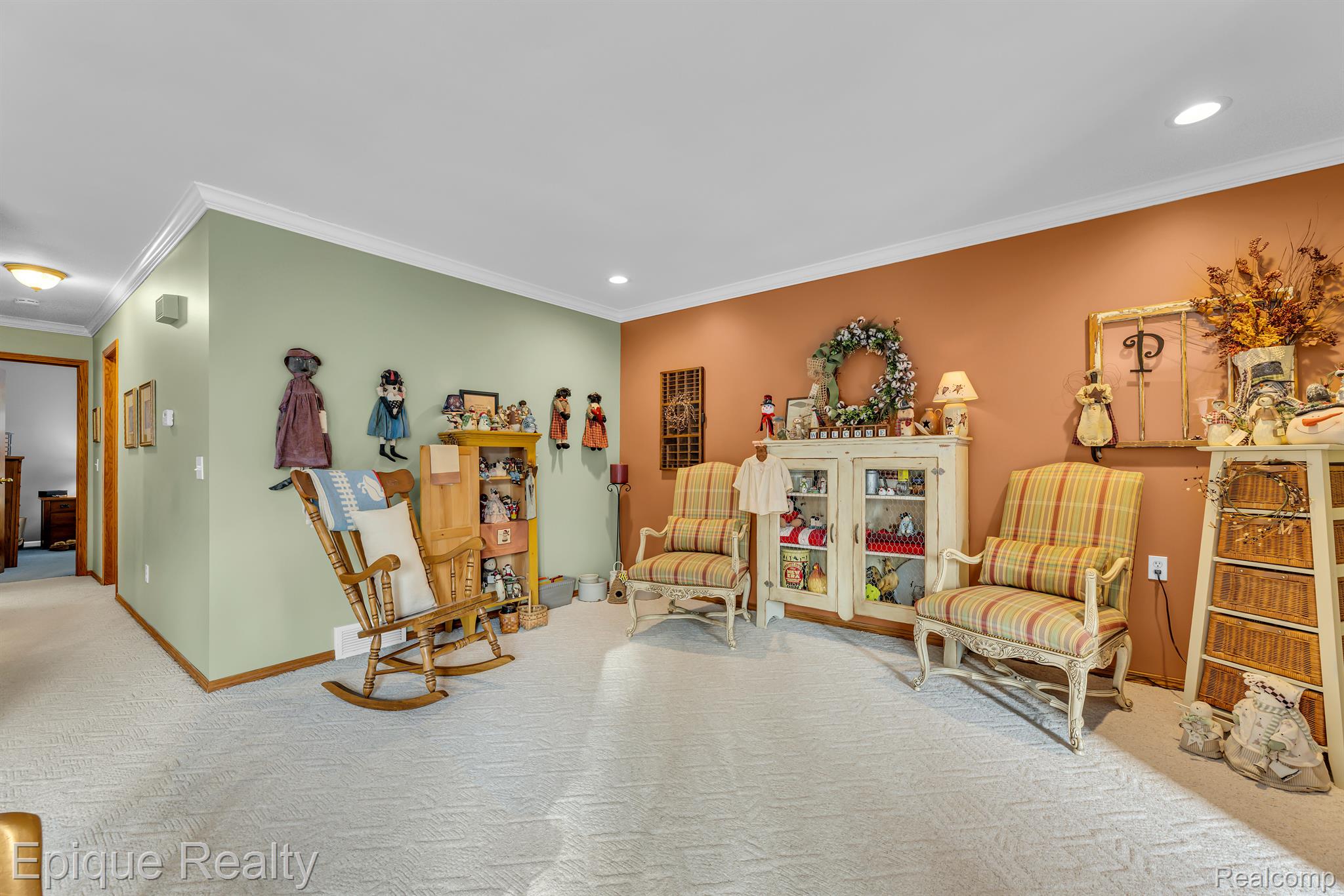 Sitting room with striped armchairs, a wooden rocking chair, and cabinets displaying dolls.