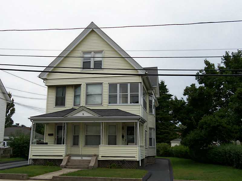 Pale yellow multi-story house with a steep gable and covered enclosed porch.