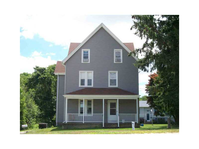 Gray multi-story house with a steep gabled roof and covered front porch.
