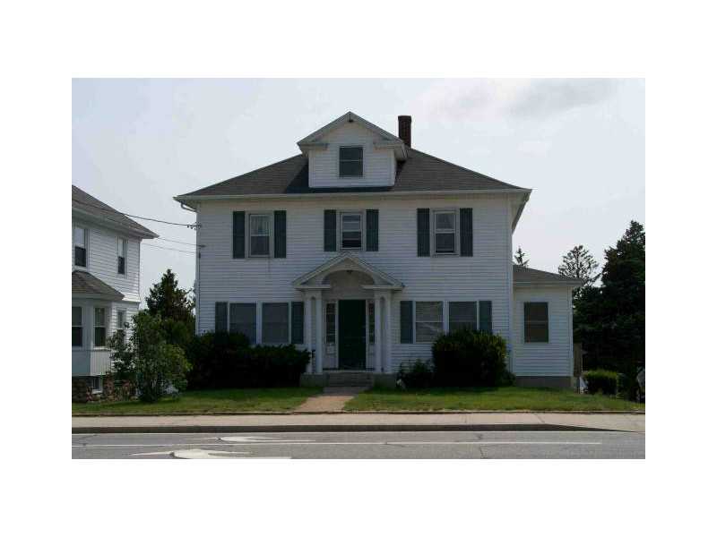 Two-story white house with a front dormer, dark shutters, and covered entrance.