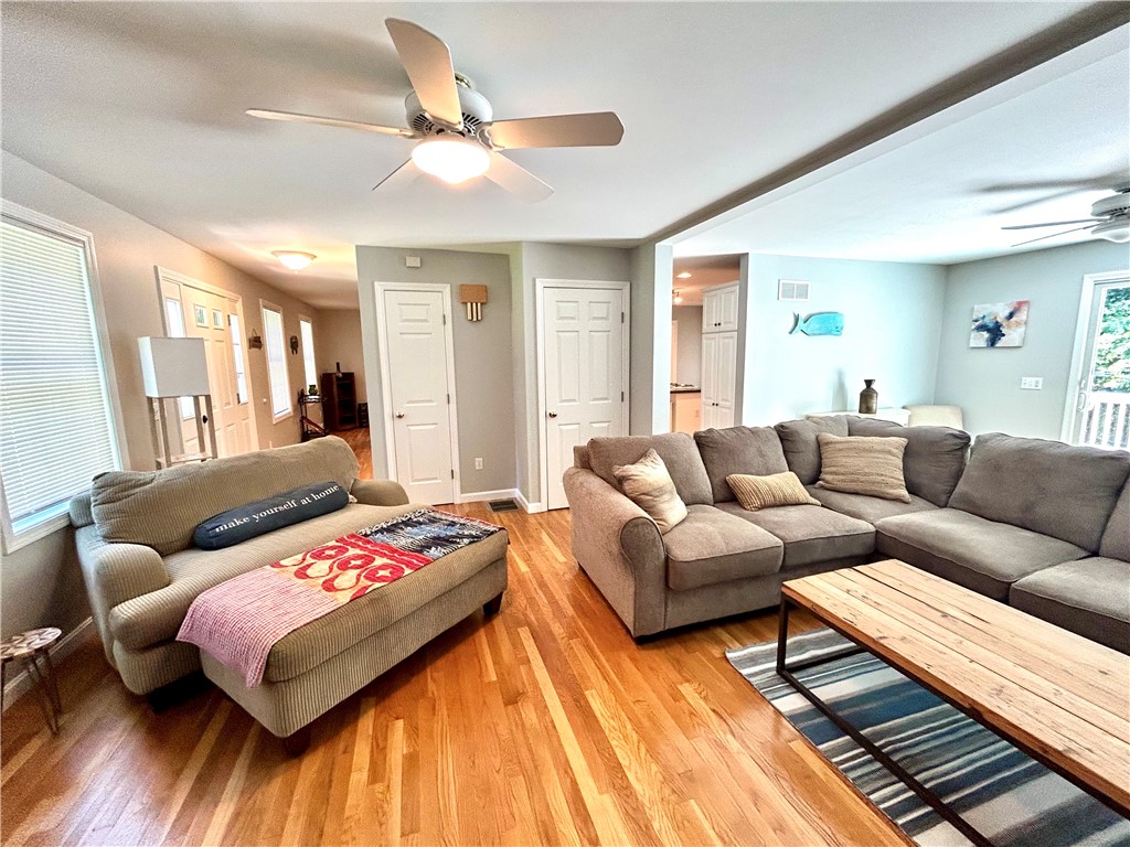 Living room with a gray sectional, chaise, hardwood floors, and a wooden coffee table.