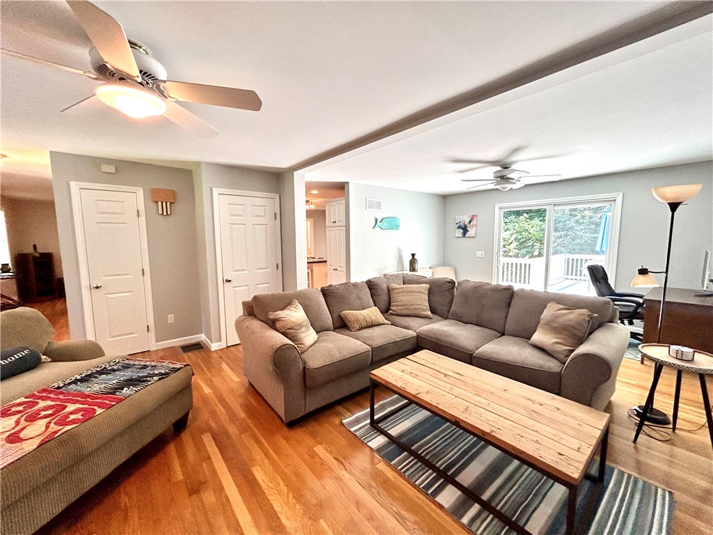 Living room with a large sectional, wood coffee table, and sliding doors to a deck.