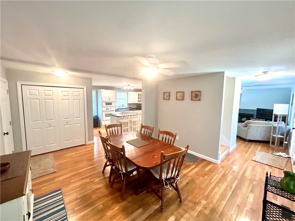 Dining area with a wooden table and hardwood floors, open to the kitchen and living room.