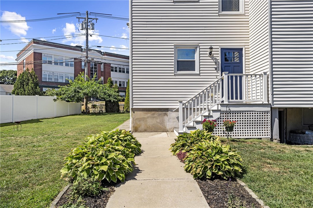 White-sided home with a blue front door, entry steps, and a landscaped walkway.