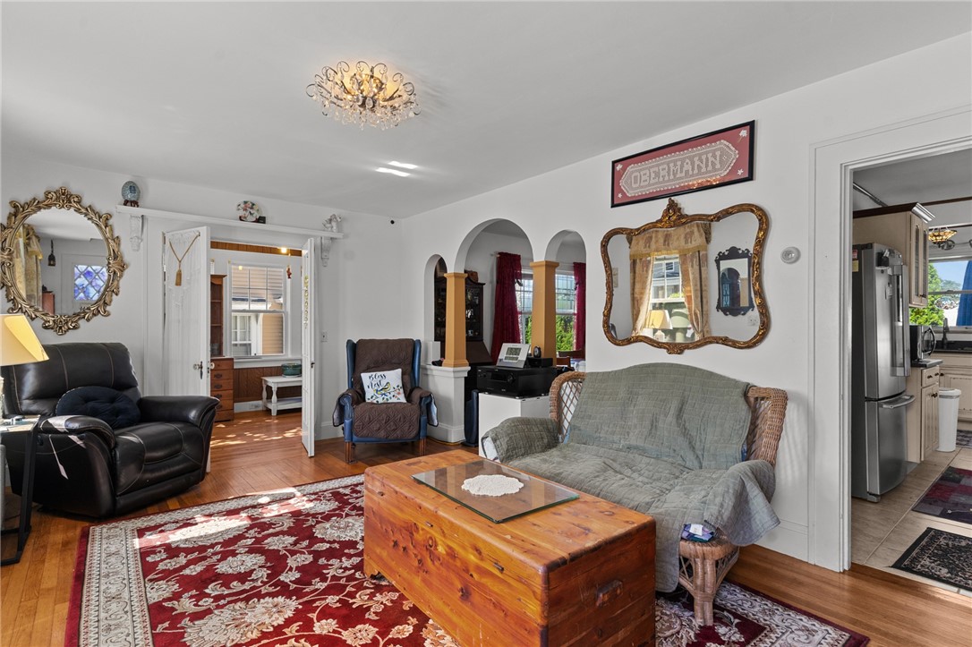 Living room with a red patterned rug, arched openings, and a wooden chest coffee table.
