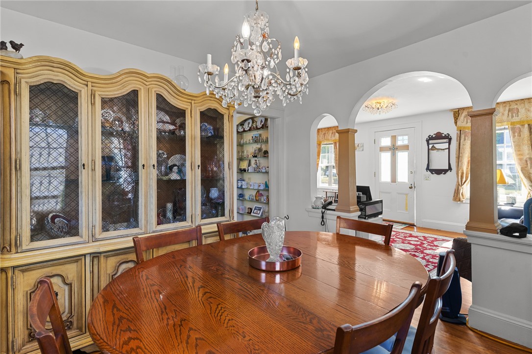 Dining room with an oval wood table, ornate china cabinet, and crystal chandelier.