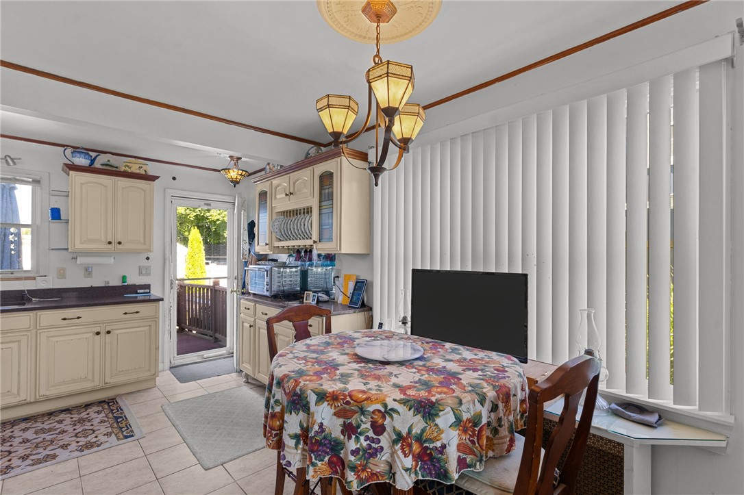 Dining area with cream cabinets, a round floral-covered table, and vertical blinds.