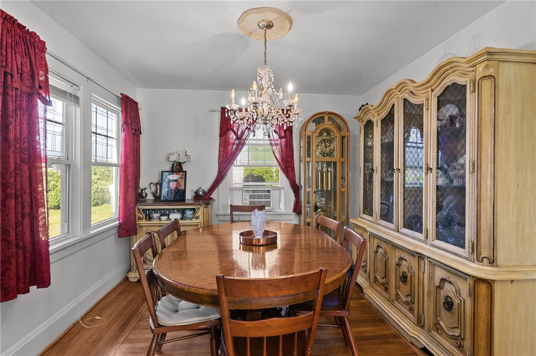 Dining room with an oval wooden table, ornate chandelier, and large carved china cabinet.