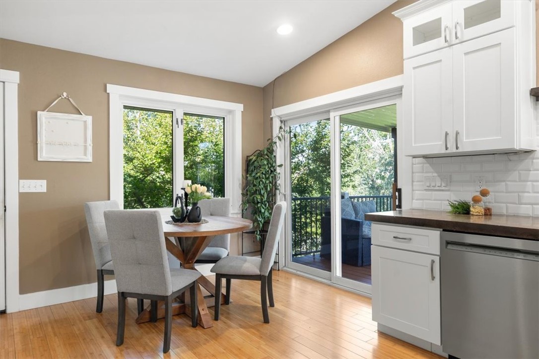 Kitchen and dining area with white cabinetry, round table, and sliding doors to a deck.