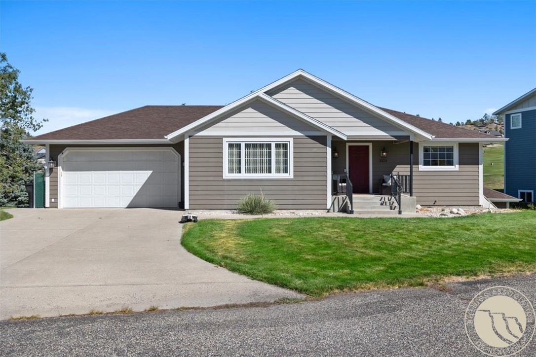 Gray single-story house with a double garage, red front door, and curved green lawn.