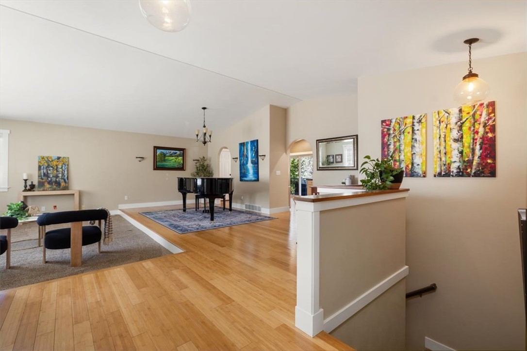 Open living area with a grand piano, hardwood floors, and colorful artwork.